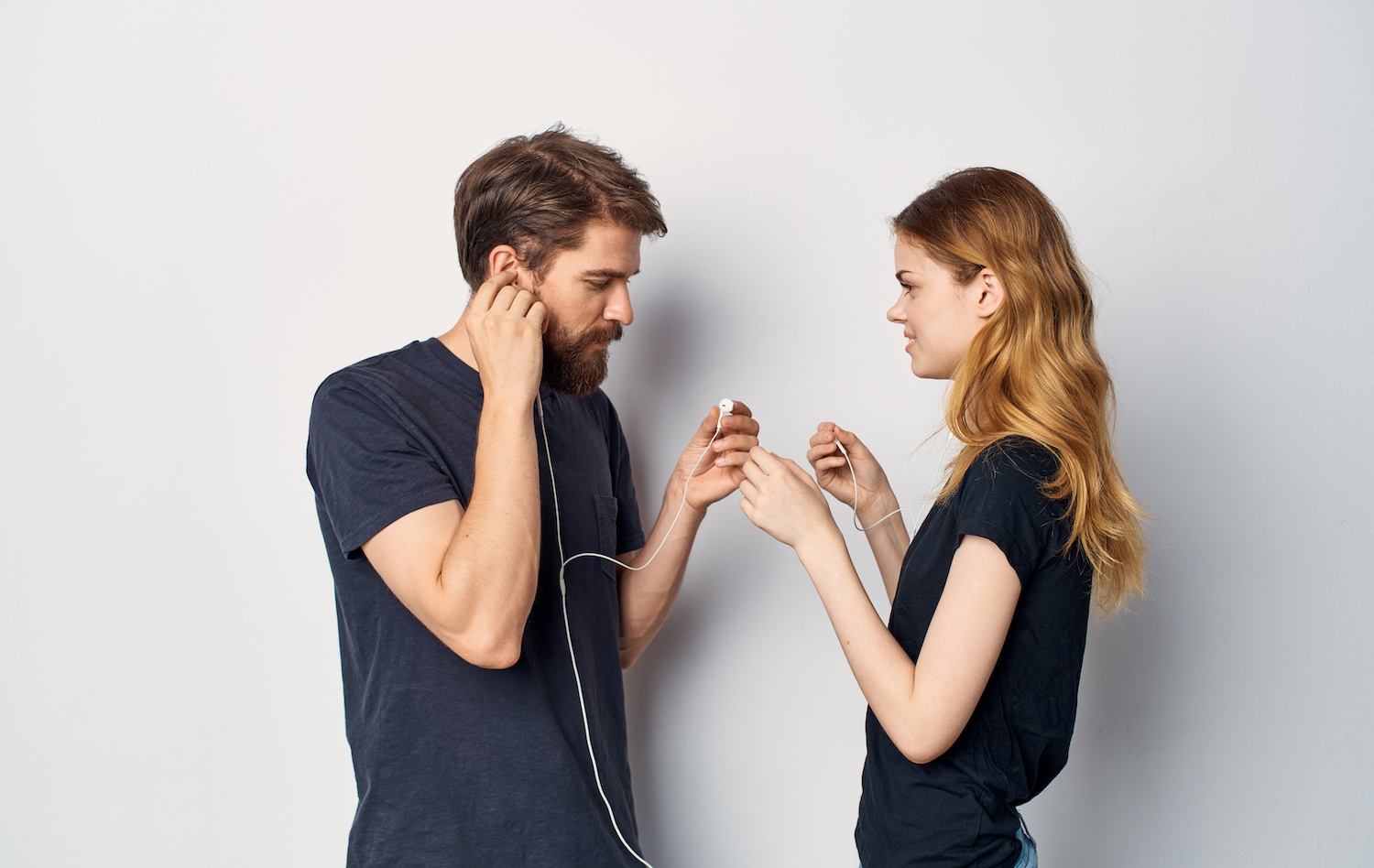 young couple in black t-shirts with headphones listening to music technology lifestyle. High quality photo