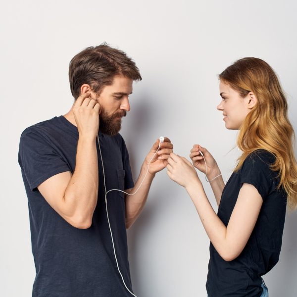young couple in black t-shirts with headphones listening to music technology lifestyle. High quality photo